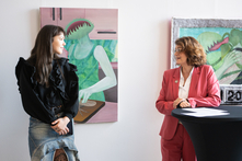 Julia Tymanska und Antje Grotheer stehen vor mehreren Gemälden.