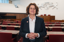 Antje Grotheer steht im Plenarsaal der Bürgerschaft und blickt freundlich in die Kamera.